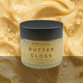 Jar of 'Butter Gloss' by milk+moss on a background of creamy texture