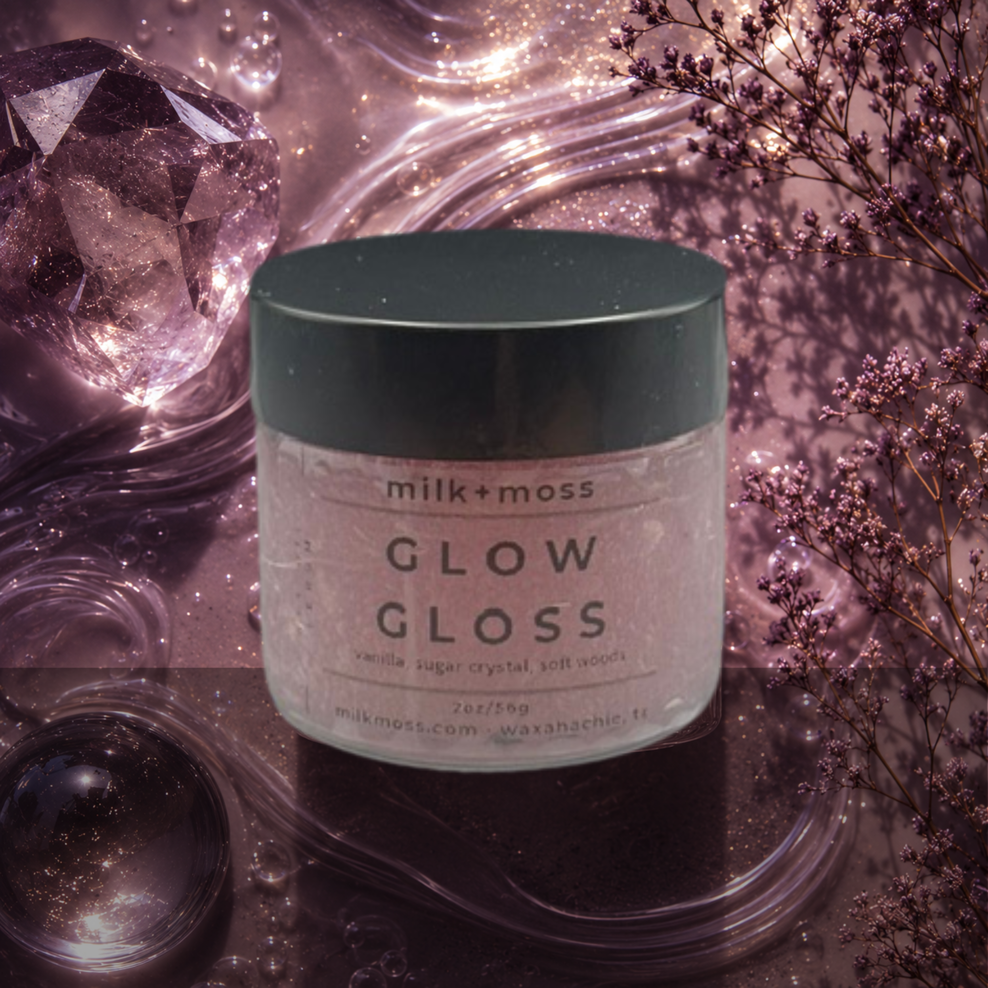 Jar of 'Glow Gloss' by milk+oss with decorative elements like crystals and flowers on a soft background.