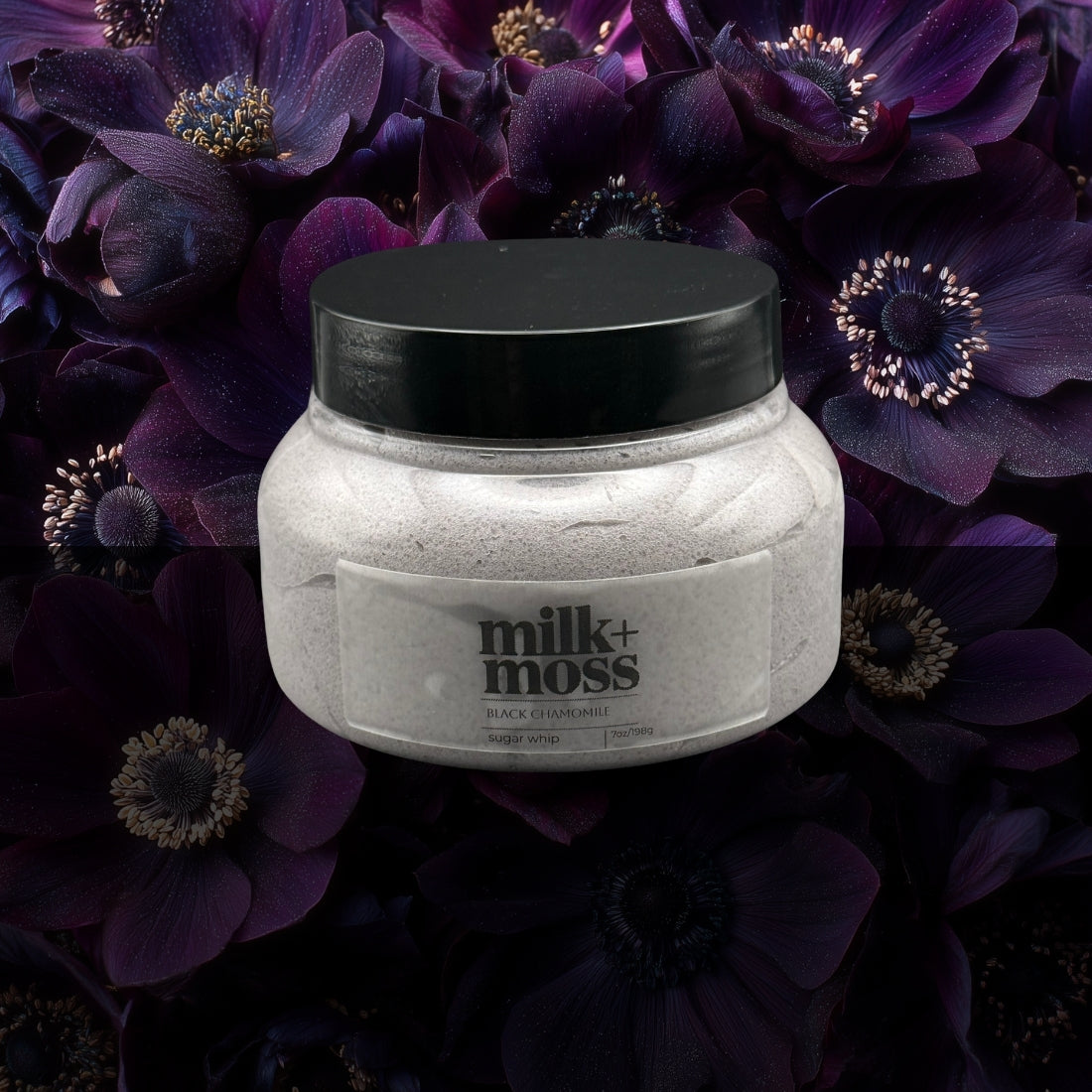 Jar of milk+moss product with black lid on a dark floral background